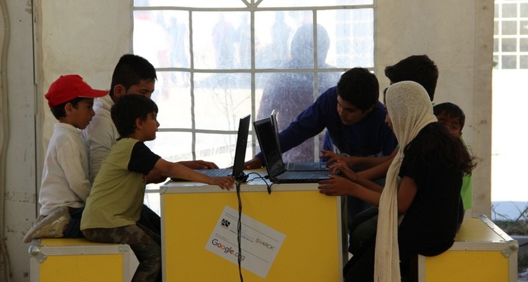 Picture of children using the computers of the Ideas Box at the Eleonas refugee camp in Athens