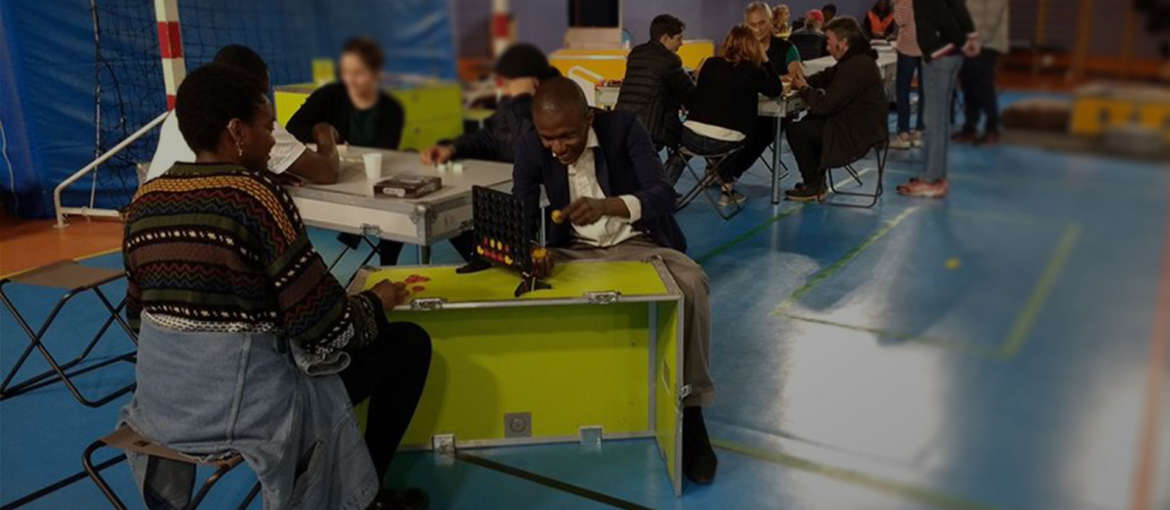 Photo d'herbergés d'urgence en gymnase jouant