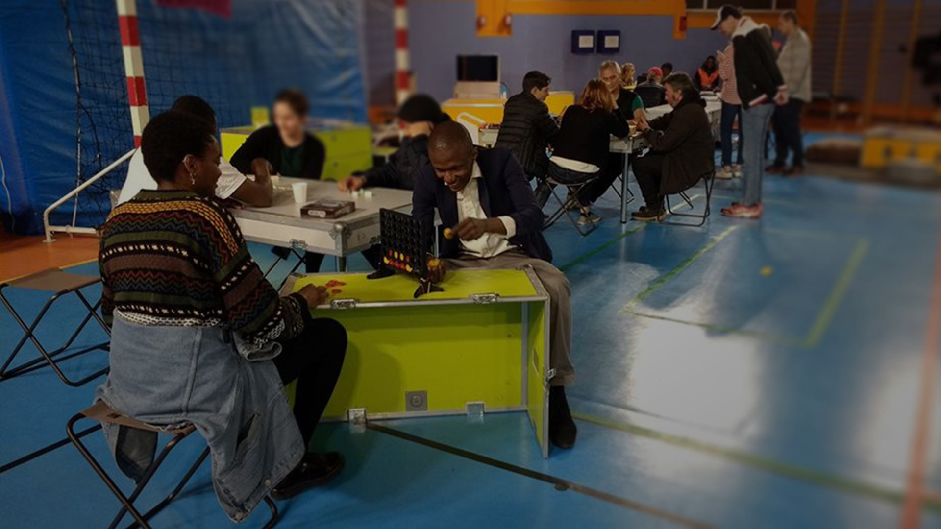 Photo d'herbergés d'urgence en gymnase jouant