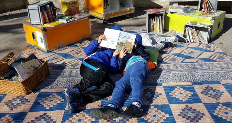 Photo d'enfants lisant par terre dans l'Ideas Box